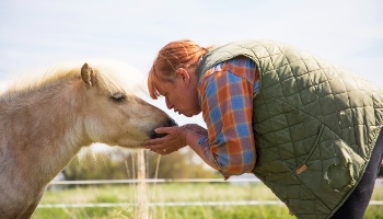 woman bowing down to kiss horse's nose © RSPCA