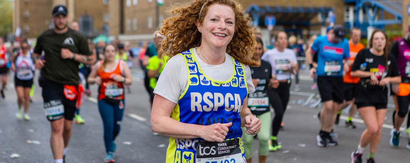 Smiling woman running in an organised road running event.