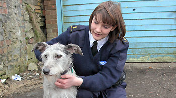 female rspca inspector with dog in front of closed garage © RSPCA