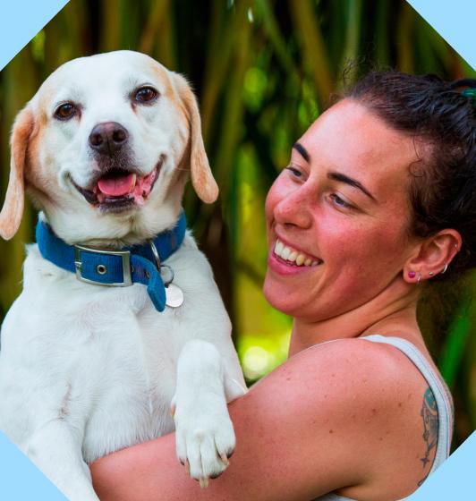 A smiling lady holding her dog within an octopunct shape.