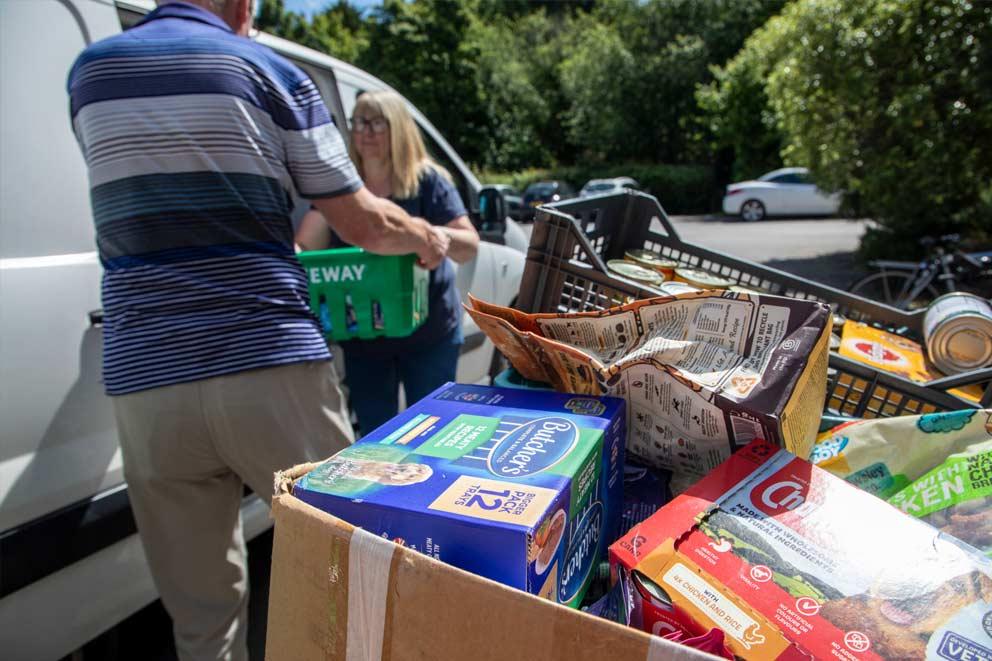 Food bank donations being delivered by two people.