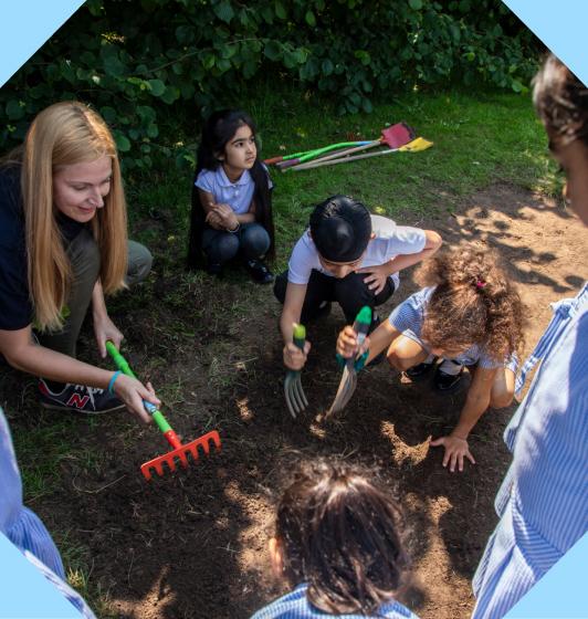 A teacher outdoors with her class within an octopunct shape.