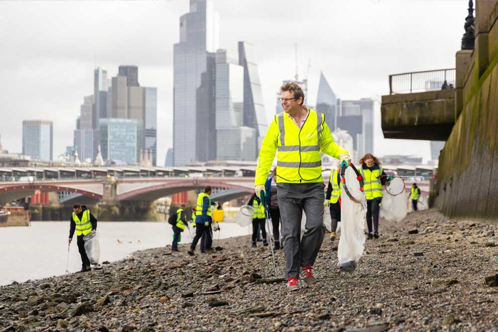 Workplace litter picking on the banks of the river Thames, London.