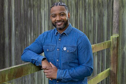 JB Gill standing by a fence