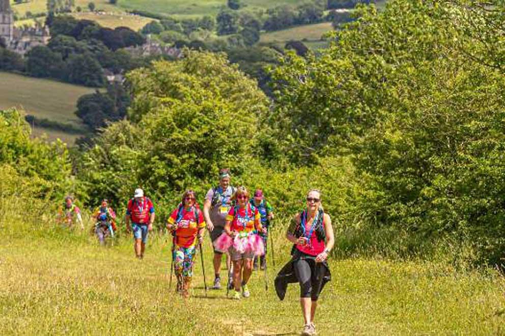 A group of walkers walking uphill in the countryside.hallenge on a sunny day.