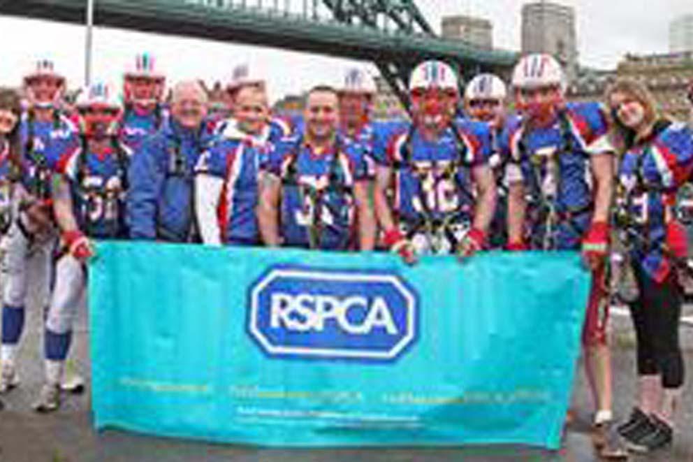 A large group of RSPCA fundraisers after abseiling over a bridge.