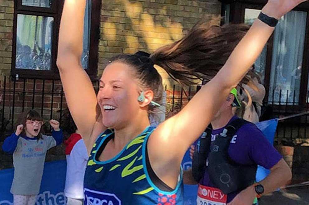 Finisher with hands in the air at an organised running event.