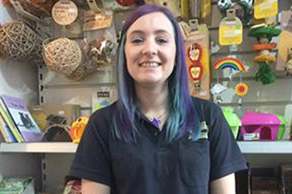 Mandy Christopher, branch trustee standing in front of items for sale in a shop.