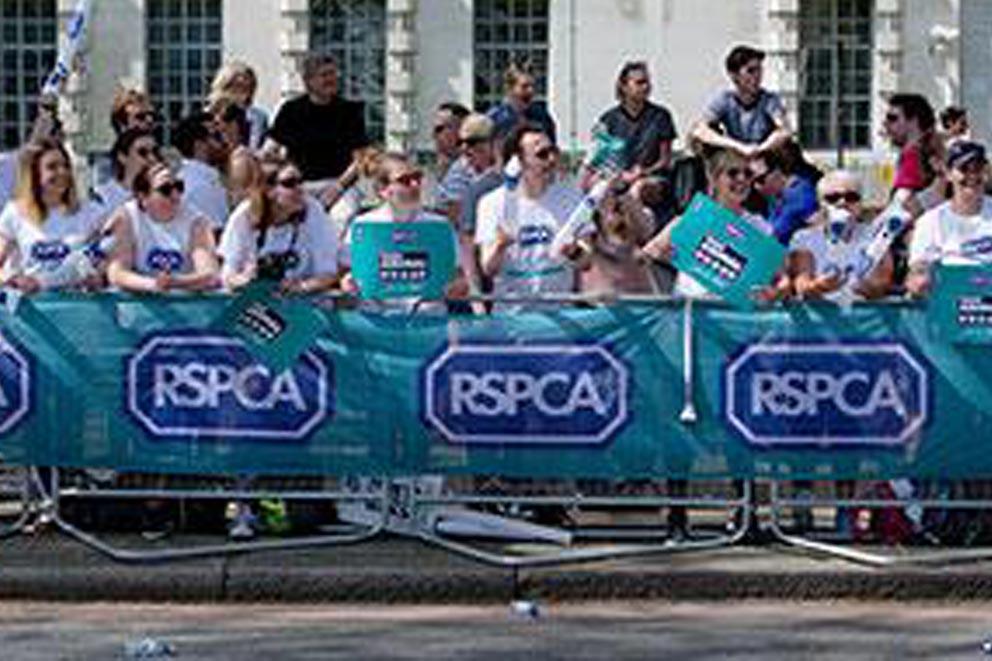 Supporters standing behind RSPCA banners at an organised running event.