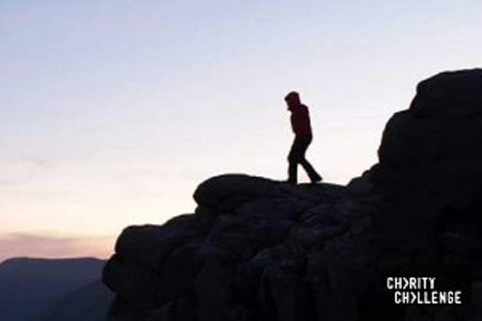 Single person standing on top of a mountain at sunrise.