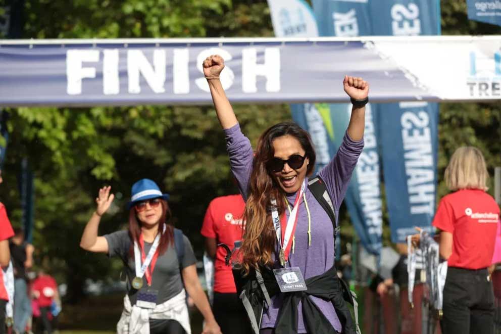 A jubilant female trekker at the finish line of an organised charity trek.